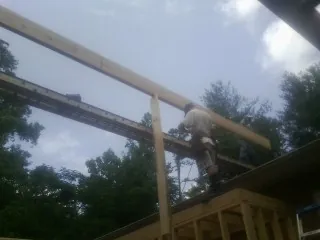 Carpenter setting a ridge beam over a new addition frame — Ice Dam Removal by Roofing Brothers in Fork