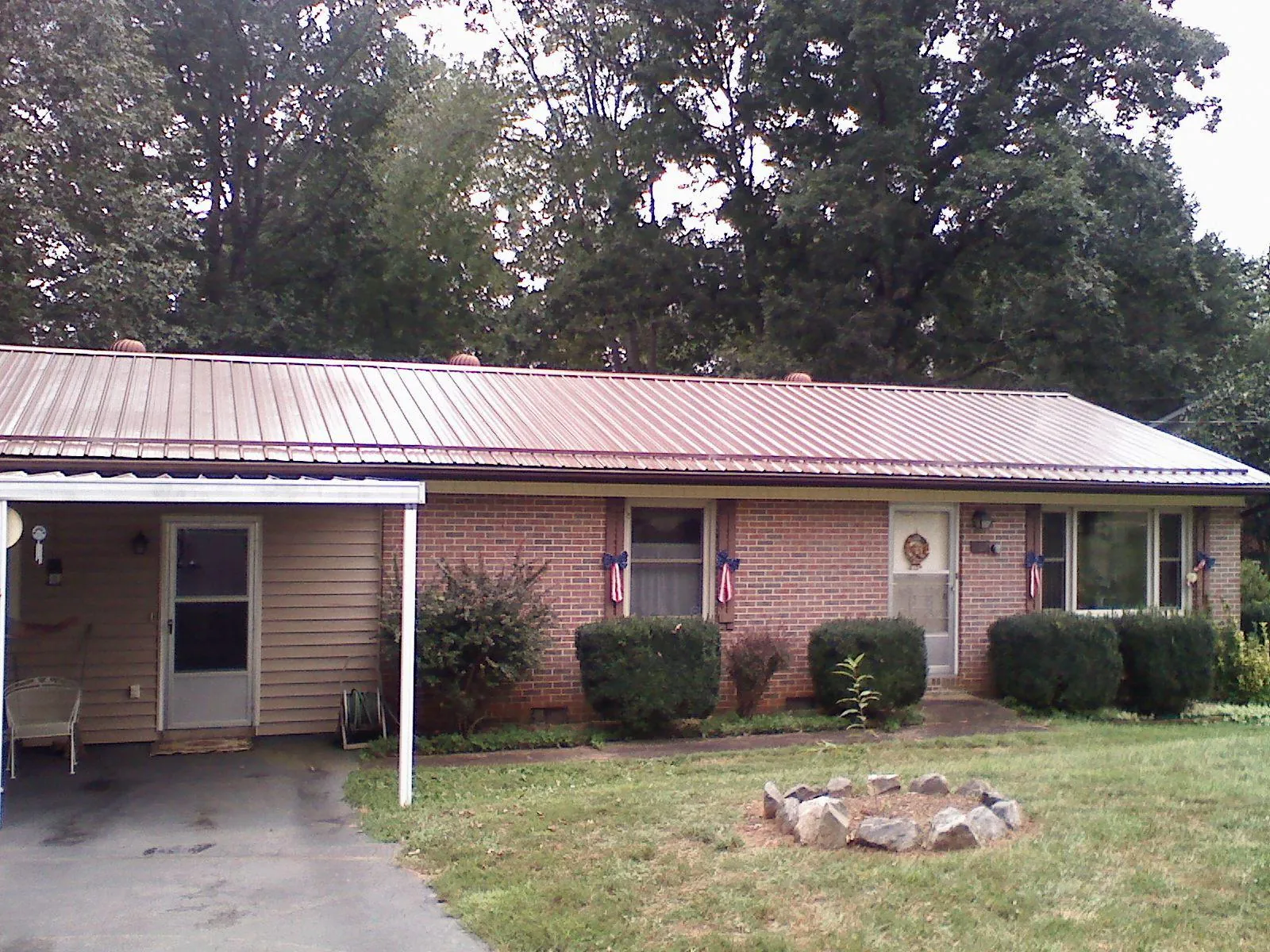 Bronze metal roof and carport on a brick ranch home — Roof Repair work by our crew in Fork